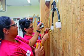 Imatge de dues dones fent pràctiques d'electricista 