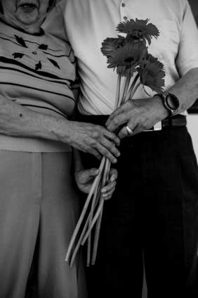 Imagen de una pareja de personas mayores con una rosa en las manos